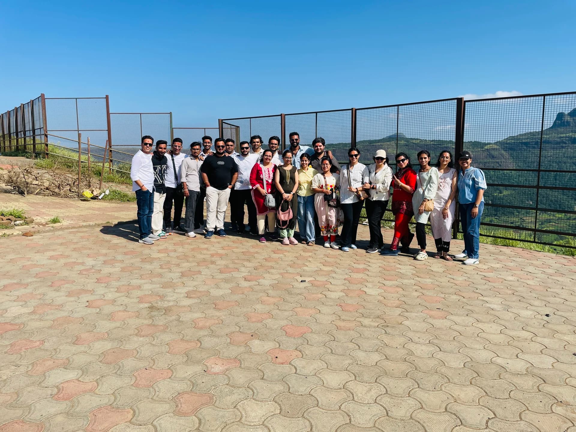 Engross teammates standing together at a scenic mountain viewpoint